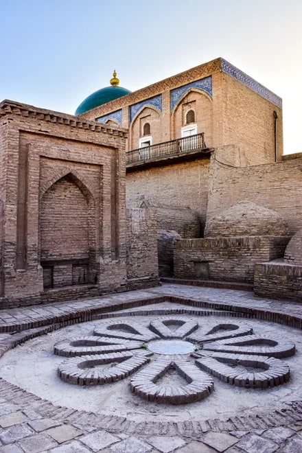 A decorative brick-floor rosette against mud-brick walls