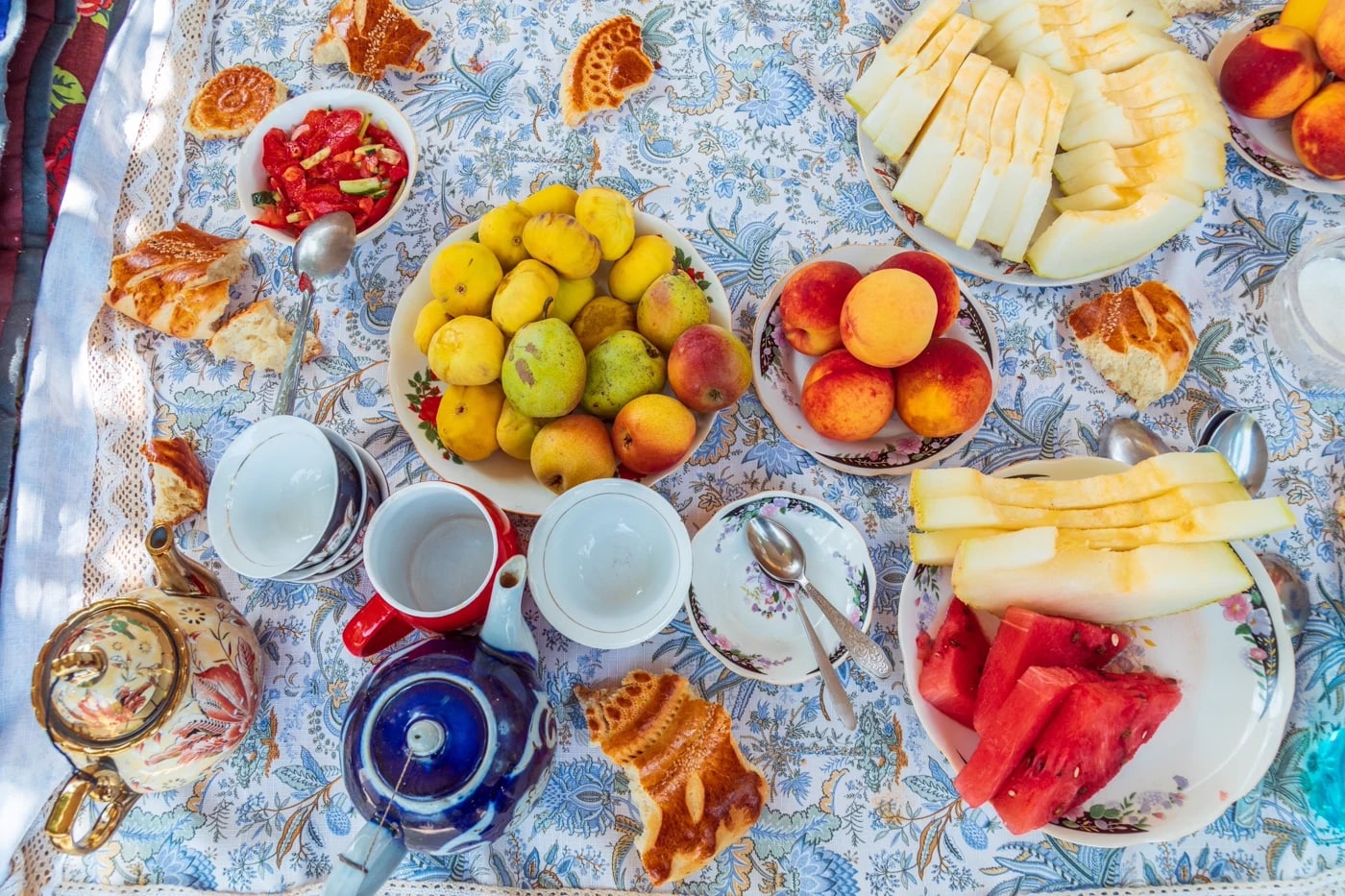 A traditional Uzbek breakfast spread of bread, melon and stone fruit